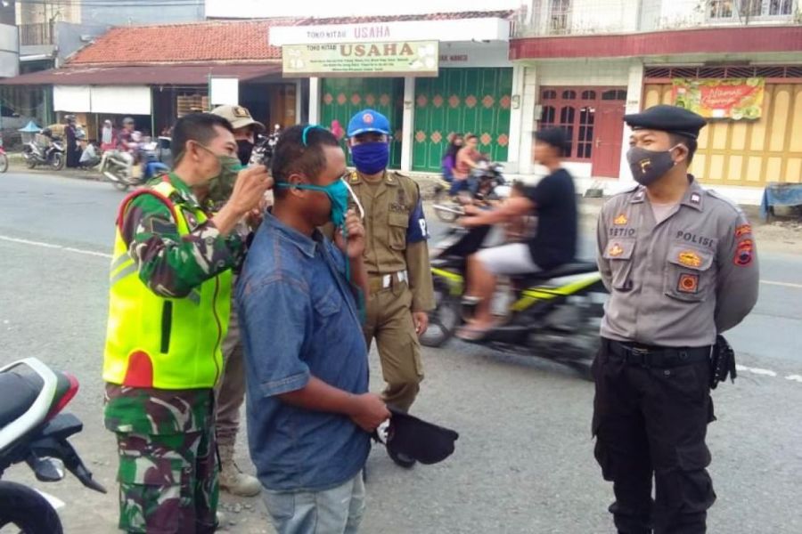 Serma Mukardi Mengenakan Masker Kepada Pengguna Jalan Yang Melintas Di Depan Pasar Pepedan