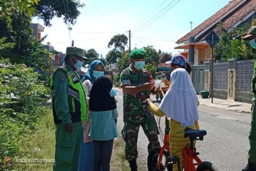 Wujud Kepedulian, Babinsa Koramil Tegal Timur Bersama Linmas Bagikan Masker Gratis